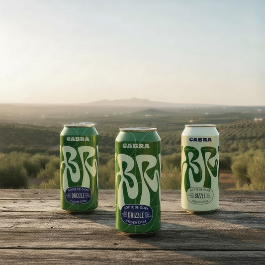 Cabra Olive Oil refill set featuring three green and white cans on a wooden table overlooking an olive grove.